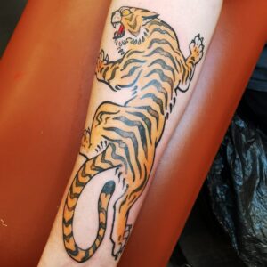 Tigertatuering på underarm.