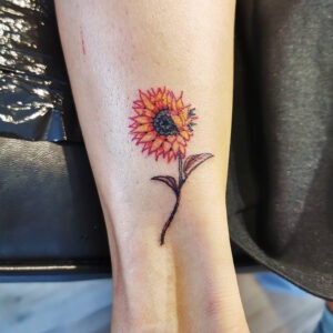Tatuering av solros på ankeln.